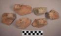 Handle sherds from miscellaneous pots. 7 are in scroll design.