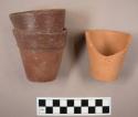 Small red ware ceramic flower pots. two are complete, but stuck together. the