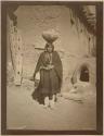 Woman balancing pot of water on head