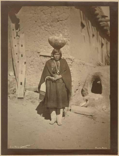 Woman balancing pot of water on head