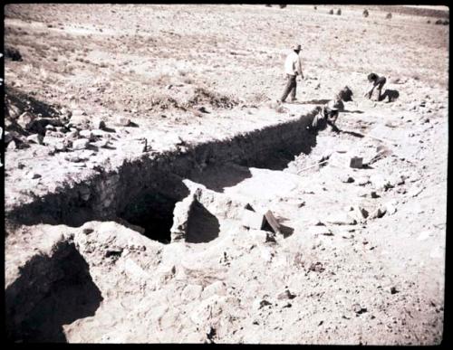 Men excavating trench, looking north