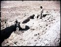 Men excavating trench, looking north
