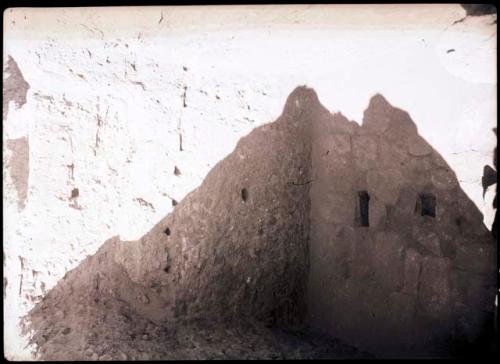 Kiva E from S., showing north wall with niche and beam seats and N. wall of Room 13 with hole to Room 11