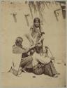Two Hopi women styling another person's hair
