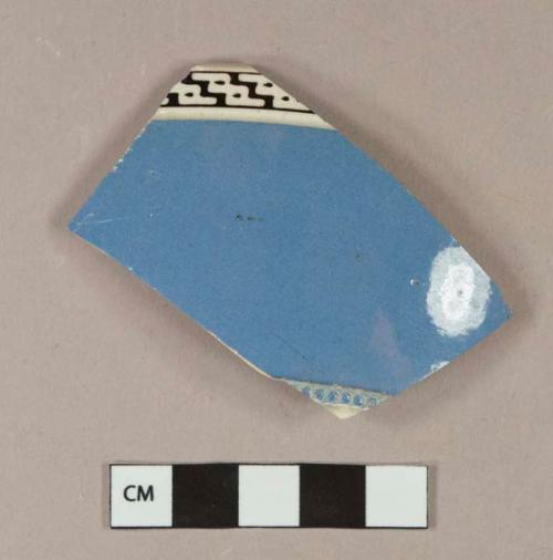 Blue and black on white slip decorated annular ware vessel body fragment, molded decoration, black "zig-zag" pattern, white paste