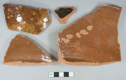 Brown lead glazed redware body, base, and rim fragments, likely dairy pans