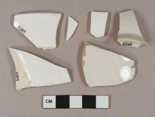 White undecorated porcelain vessel body, base, and rim fragments, some likely apothecary or medicine ceramics