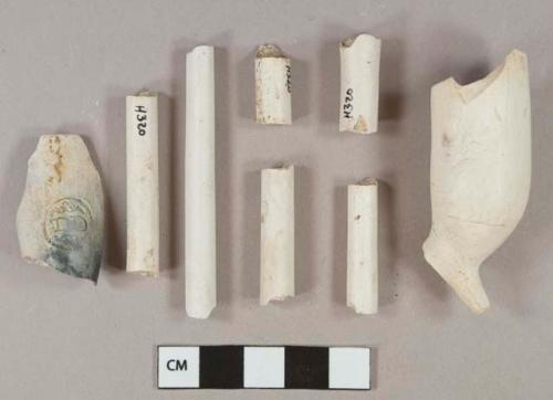 White kaolin pipe stem and bowl fragments, 1 bowl stamped with "TD" cartouche, 1 stem with 4/64" bore diameter, 5 stems with 5/64" bore diameter