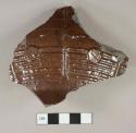 Dark brown salt glazed stoneware fragment, gray paste with visible temper, molded, possible sewer or water pipe fragment