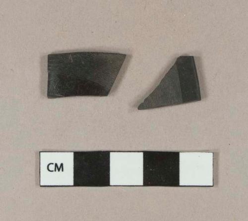 Black plastic record fragments; one fragment embossed on one side with "...133" and on the other side with "...3672..."