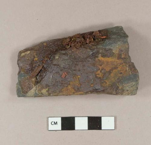 Non-cultural stone fragment with unidentified iron fragments adhered to it