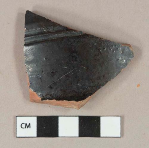 Black opaque lead glazed exterior, brown lead glazed interior, redware vessel body fragment