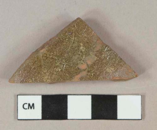 Greenish brown lead glazed redware vessel body fragment, unglazed interior