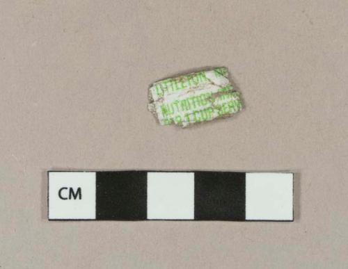 White synthetic fragment printed in green with "LITTLETON, MA / NUTRITION IN... / ...R 1 CUP SERV..."