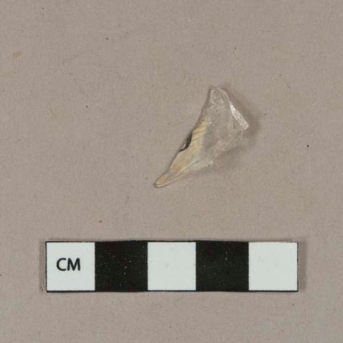 Colorless bottle glass fragment with fragment of paper label on it