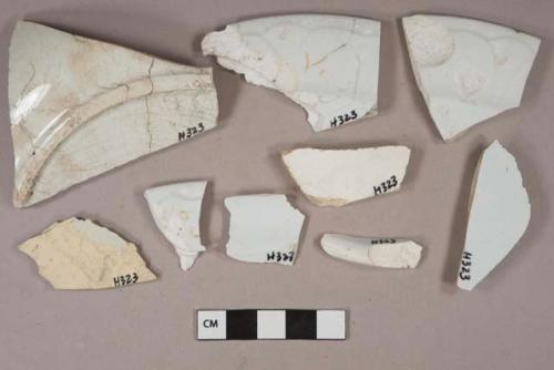 Undecorated white pearlware vessel body, base, and rim fragments, white paste