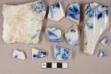 Flow blue transferprinted pearlware vessel body, base, and rim fragments, white paste