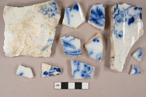 Flow blue transferprinted pearlware vessel body, base, and rim fragments, white paste