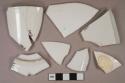 White porcelain vessel base, body, and rim fragments, white paste, some fragments molded, 2 fragments heavily burned