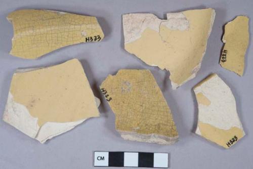 Undecorated yellow ware vessel body, base, and rim fragments, buff paste