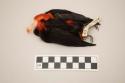 Feather ornament, one black and red bird body