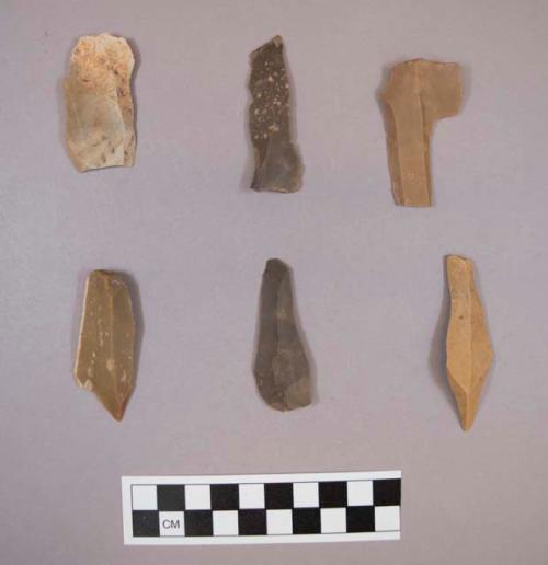 Flint flakes and blades, including tan, brown, grey and cream colored stone, some contain cortex