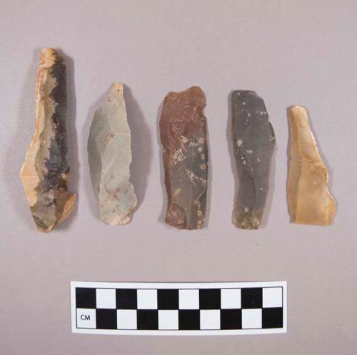 Flint flakes and blades, including tan, grey, brown, cream and red colored stone, some contain cortex