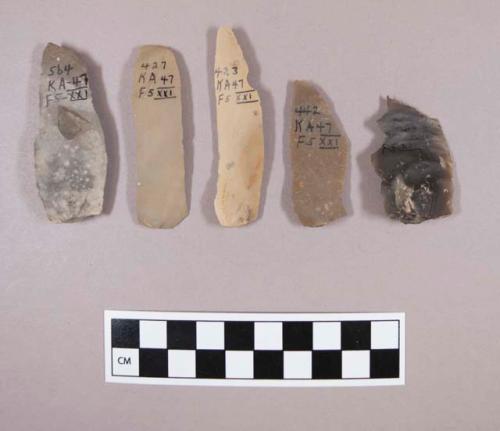 Flint flakes and blades, including tan, grey, brown and cream colored stone, some contain cortex