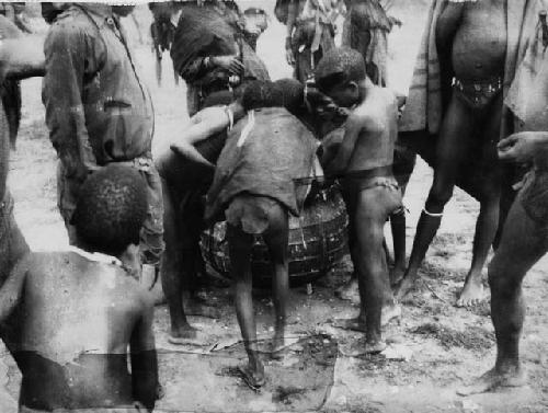 Children getting mealie meal from a large iron pot