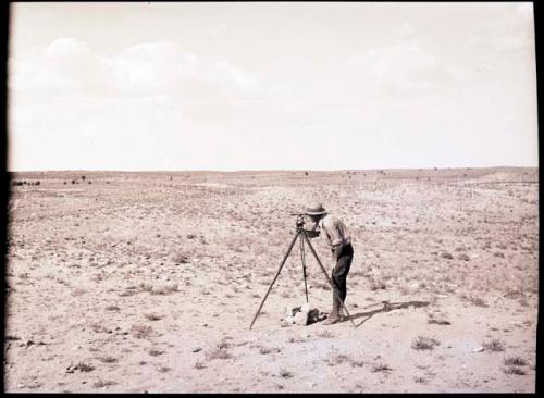 Someone surveying, using alidade