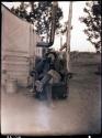 Jo Brew in chair beside tent, smoking