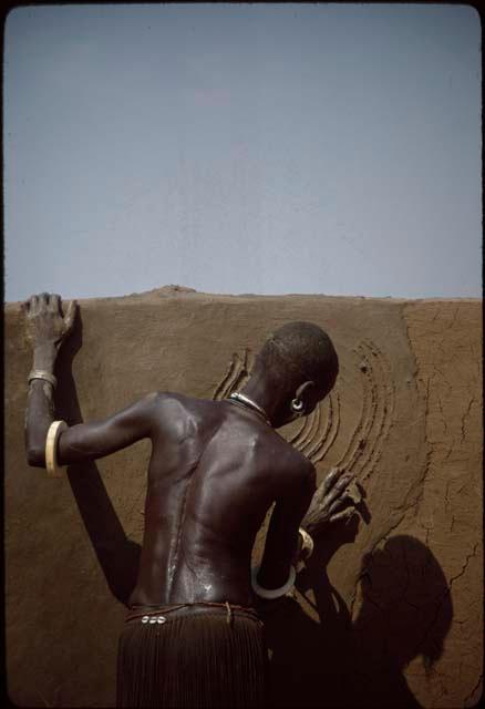 Nuer woman painting house