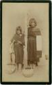 Woman and girl standing next to post
