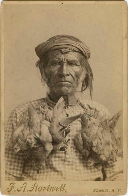 Portrait of a man wearing string of birds around his neck