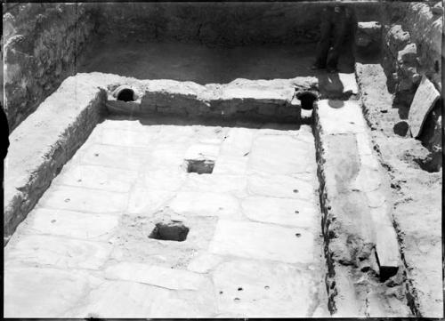 Test 14, room 6, kiva, looking south buried jars in bench, loom holes in floor.