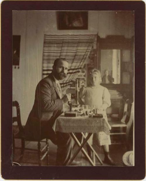 John G. Owens with a child at a table, possibly instructing