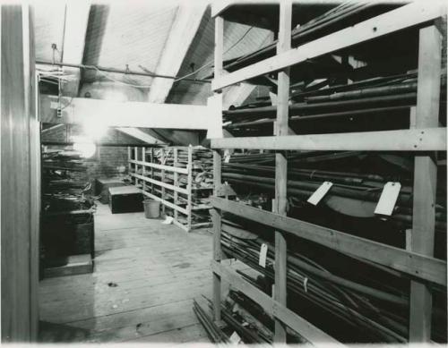 Historical photograph of Peabody Museum attic storage with various wooden objects