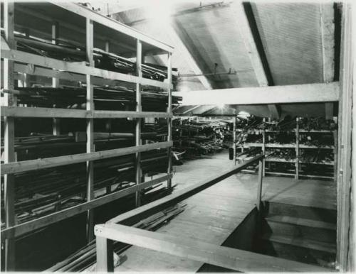 Historical photograph of Peabody Museum attic storage shelving with wooden objects