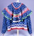 Blouse of figured blue cotton. Red, blue, green and yellow ribbon.