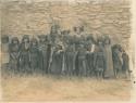 Group of Hopi girls standing in front of a stone wall