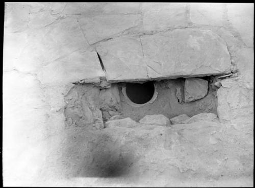 Room 4, general view from N before complete excavation, shows pot, masonry wall