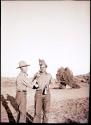 Al in plaza, clowning with Burt Cosgrove. It is Al's birthday and he is wearing a feathered headdress