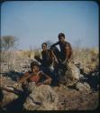 "Young Men": Three men sitting on rocks