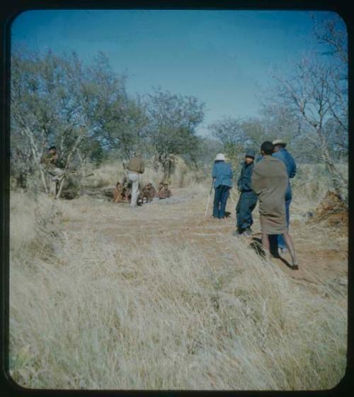 Expedition: Lorna Marshall photographing a group of people and John Marshall adjusting arrangements, with other expedition members present