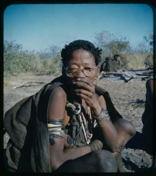 Portraits: Woman sitting and wearing someone’s glasses