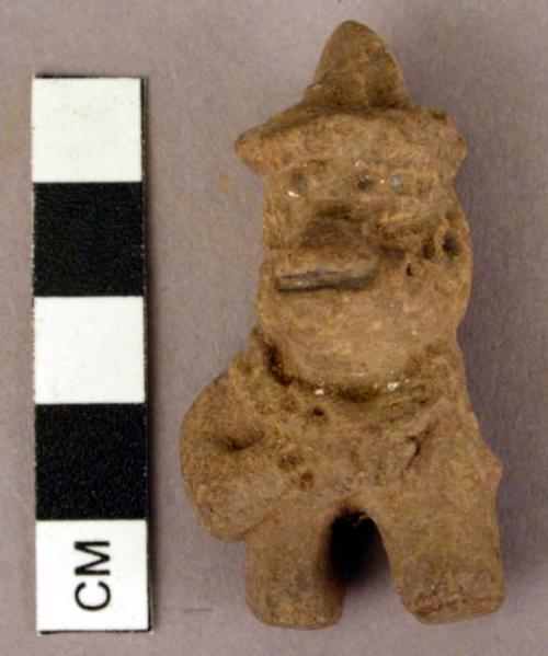 Crude unpainted human figurine with appliqued and punctate decoration.