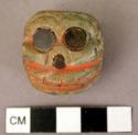 Small carved skull of gray-green stone-traces of vermillion coloring