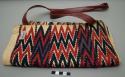 Bag of natural cotton with black, red and purple brocade zigzag design; leather strap