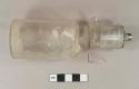 Colorless glass bottle, two fragments crossmend. Two piece mold, tooled patent finish. Metal spout cap still intact. Colorless bottle glass fragment, crossmends with bottle