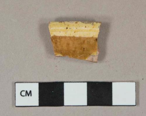 Red and yellow slip glazed redware vessel rim fragment